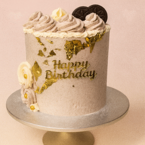 Gâteau d’anniversaire doré décoré de crème, éclats dorés et biscuits – BGS Pâtisserie Nantes